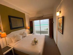 a bedroom with a large white bed with flowers on it at Seaview Deluxe@Rainbow Paradise Tg Bungah 4-6pax in Tanjung Bungah