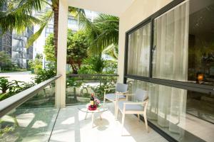 Habitación con balcón con mesa de cristal y sillas. en Diamond Bay Condotel Resort Nha Trang en Nha Trang