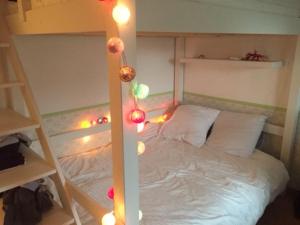- une chambre dotée d'un lit avec des lumières de Noël dans l'établissement Maison 3 chambres, à Bruz