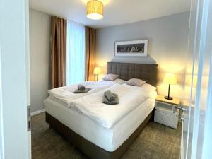 a bedroom with a large bed with two pillows on it at Baltic Lagoon Resort - Appartement 12 in Fuhlendorf