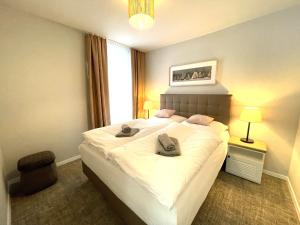 a bedroom with a large white bed with two towels on it at Baltic Lagoon Resort - Appartement 12 in Fuhlendorf