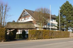 ein großes Haus mit Strohdach auf einer Straße in der Unterkunft Baltic Nr. 5 in Scharbeutz