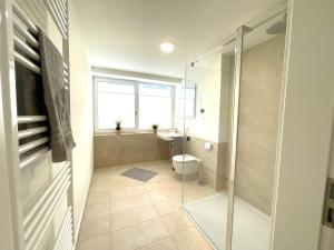 a bathroom with a toilet and a glass shower at Baltic Lagoon Resort - Appartement 12 in Fuhlendorf +24 photos