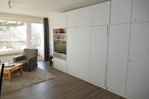 ein Wohnzimmer mit weißen Schränken und einem Tisch in der Unterkunft Baltic Nr. 5 in Scharbeutz