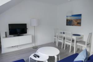 a living room with a tv and a table and chairs at Baltic Nr. 24 in Scharbeutz
