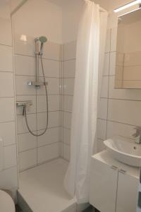 a shower with a shower curtain next to a sink at Baltic Nr. 24 in Scharbeutz