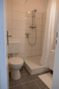 a white bathroom with a toilet and a shower at Baltic Nr. 24 in Scharbeutz +11 photos