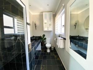 a bathroom with a toilet and two sinks and a shower at On The Estuary in Knysna