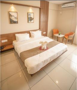 a hotel room with a large bed in a room at Samasth Palatial in Mysore