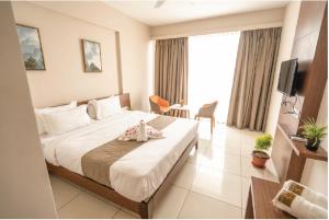 a hotel room with a large bed and a television at Samasth Palatial in Mysore