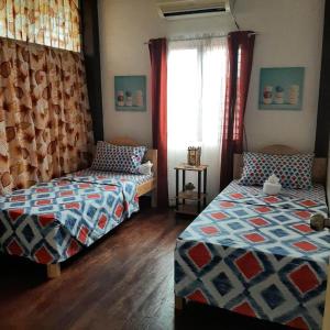 a bedroom with two beds and a window at Ella's Beach House in Tuble +17 photos