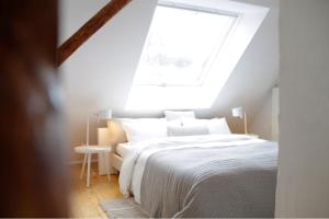 um quarto com uma cama branca e uma clarabóia em Charmantes Quartier in einem Fachwerkhaus em Stadthagen