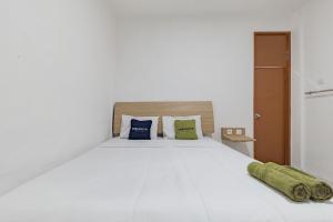 - une chambre avec un lit blanc et 2 oreillers dans l'établissement Urbanview Hotel Cozy Samarinda by RedDoorz, à Samarinda