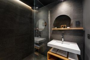 La salle de bains est pourvue d'un lavabo et d'une douche. dans l'établissement Polynesian Cabins by Kon Tiki, à Papeete