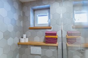 a bathroom with a shower and a window and towels at Apartmány Jabloneček in Jablonec nad Jizerou