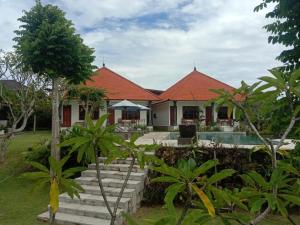ウルワツにあるBatu Jaran Hill Cottage Uluwatuのオレンジ色の屋根の家