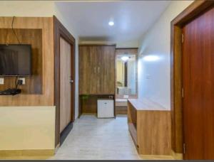a room with a kitchen with a counter and a television at Royal shades kodihali in Bangalore