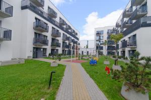 an apartment complex with a playground in the middle of a yard at Modern Apartment Next to Ozas park by URBAN RENT in Vilnius