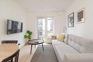 a living room with a white couch and a table at Modern Apartment Next to Ozas park by URBAN RENT in Vilnius