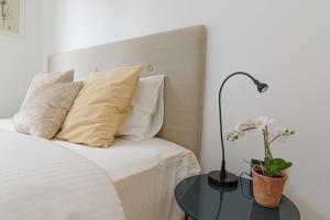 ein Schlafzimmer mit einem Bett und einem Tisch mit einer Lampe in der Unterkunft Modern Apartment Next to Ozas park by URBAN RENT in Vilnius