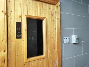 a bathroom with a mirror and a wooden wall at Cozy Suite with 270 Degree Mountain and Theme Park Views in Ipoh