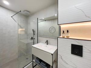 uma casa de banho branca com um lavatório e um chuveiro em GRIFID Moko Beach - 24 Hours Ultra All Inclusive & Private Beach em Golden Sands