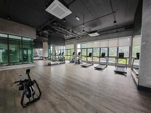 a gym with treadmills and exercise equipment in a room at Cozy Suite with 270 Degree Mountain and Theme Park Views in Ipoh