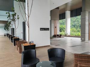 a lobby with chairs and tables and windows at Cozy Suite with 270 Degree Mountain and Theme Park Views in Ipoh
