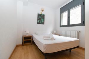 a bedroom with a white bed and a window at Apartamentos Canillo 3000 in Canillo