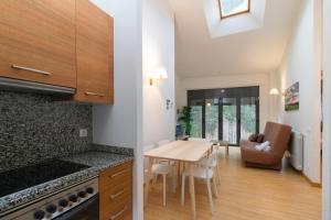a kitchen and dining room with a table and chairs at Apartamentos Canillo 3000 in Canillo