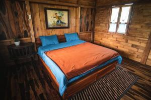 een slaapkamer met een bed in een houten hut bij Singgasana Villa & Resto in Bedakah