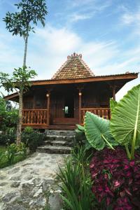 een klein houten huis met een dak bij Singgasana Villa & Resto in Bedakah