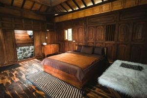 een slaapkamer met een bed in een houten kamer bij Singgasana Villa & Resto in Bedakah