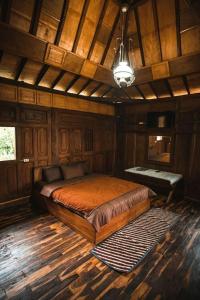 Bedakah的住宿－Singgasana Villa & Resto，木制客房内的一间卧室,配有一张床