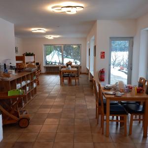 a kitchen and dining room with tables and chairs at Pension Alpina in Roppen