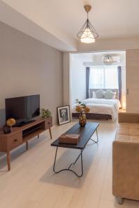 a living room with a bed and a tv at FDS ZEAL in Osaka