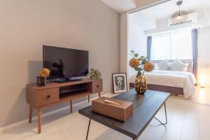 a bedroom with a bed and a television on a table at FDS ZEAL in Osaka