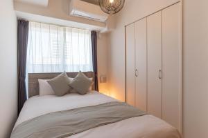 a bedroom with a large bed and a window at FDS ZEAL in Osaka