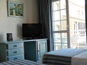 a bedroom with a tv on a dresser with a window at Hotel Villa de Laredo in Fuengirola