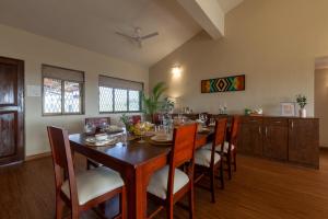 a dining room with a wooden table and chairs at Emerald Greens by VEO - Part of StayVista in Lonavala