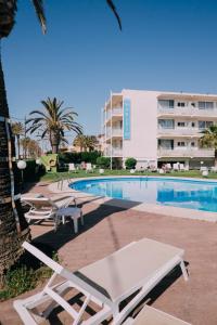 una piscina con tumbonas y un edificio en Hotel Subur Maritim, en Sitges