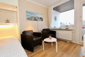 una camera da letto con un letto, una sedia e un tavolo di Ferienwohnung Strandmarie, Haus Loreley, App. 14 a Sankt Peter-Ording
