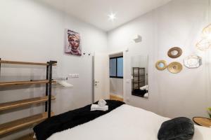 マドリードにあるLuxury Suite in Plaza Tirso Molinaの白いベッドルーム(ベッド1台、鏡付)