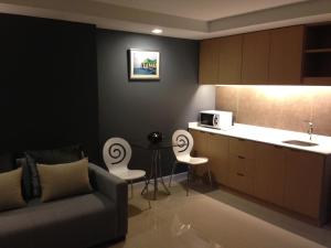 a living room with a couch and a kitchen at The Aim Sathorn Hotel in Bangkok
