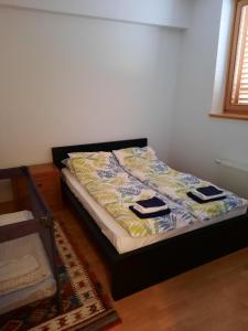 ビイェラシュニツァにあるThe Snow Crib Bjelasnica Aptのベッド1台(タオル2枚付)が備わる客室です。