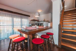 a kitchen with a bar with red stools at Kuca za odmor M11 in Kupres