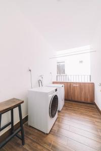uma lavandaria com uma máquina de lavar roupa e uma mesa em The Green House Villa em Da Lat