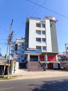 um edifício branco com escadas em frente a uma rua em HOTEL GOLDEN ORCHID em Dibrugarh