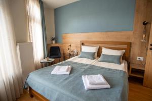 1 dormitorio con 1 cama con 2 toallas en Boutique Hotel St Nikolas by Skar, en Kruševo