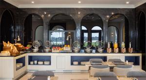 a dining room with a table and chairs and mirrors at Eastin Hotel Vientiane in Vientiane